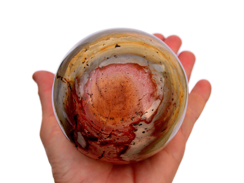 Large polychrome jasper sphere mineral 90mm on hand with white background