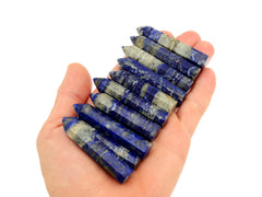 Ten lapis lazuli mini faceted points 50mm-55mm on hand with white background
