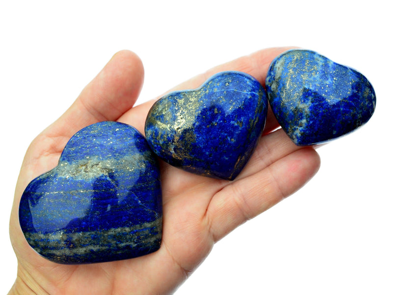 Three lapis lazuli heart stones 40mm-65mm on hand with white background