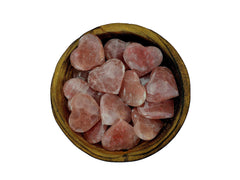 Several rose calcite hearts 30mm-40mm inside a wood bowl on white background