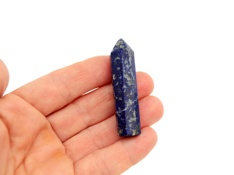 One mini lapis lazuli crystal point 50mm on hand with white background