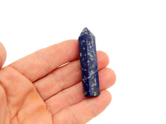 One mini lapis lazuli crystal point 50mm on hand with white background