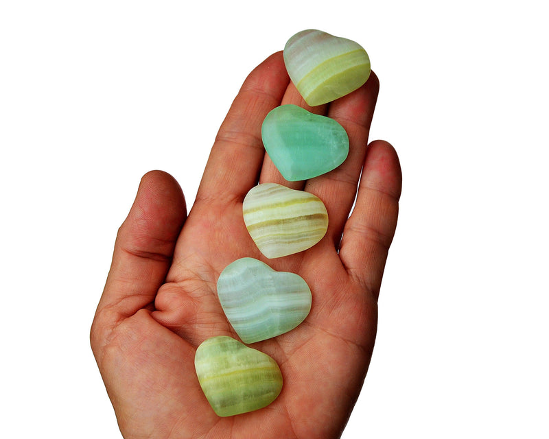 Five pistachio green calcite hearts 30mm-35mm on hand with white background
