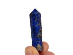One lapis lazuli crystal point 40mm on hand with white background