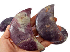 Two large purple lepidolite moon crystals 90mm on hand with background with some stones