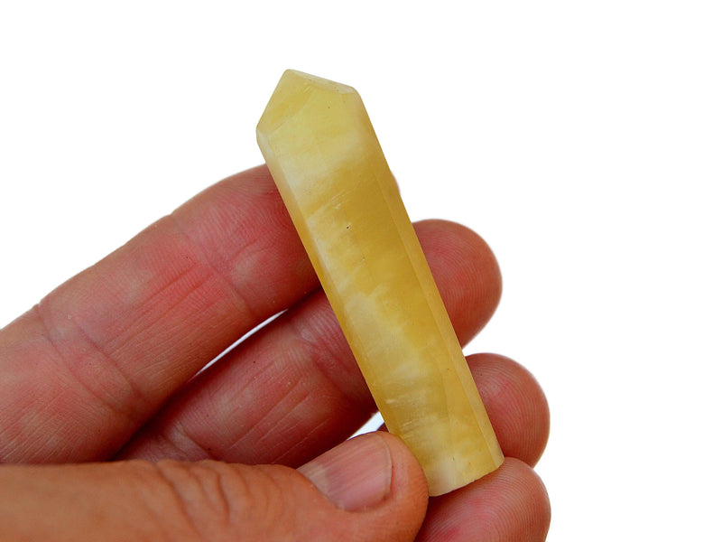 One yellow calcite crystal point 60mm on hand with white background