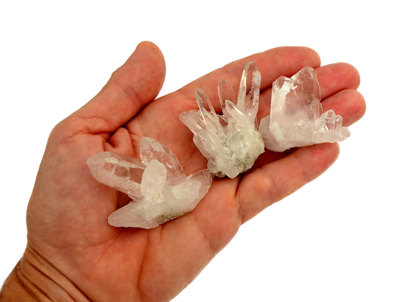 Three mini clear quartz crystal druzies 30mm on hand with white background