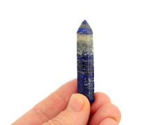 One faceted lapis lazuli point 55mm on hand with white background