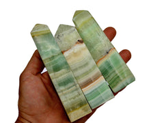 Three pistachio calcite towers 125mm on hand with white background