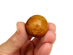 Yellow hematoid quartz sphere 25mm on hand with white background