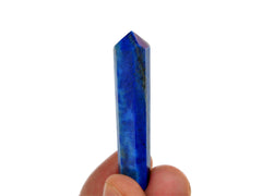 One cobalt blue lapis lazuli crystal point 50mm on hand with white background
