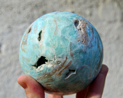 Druzy blue aragonite sphere 70mm on hand with white background