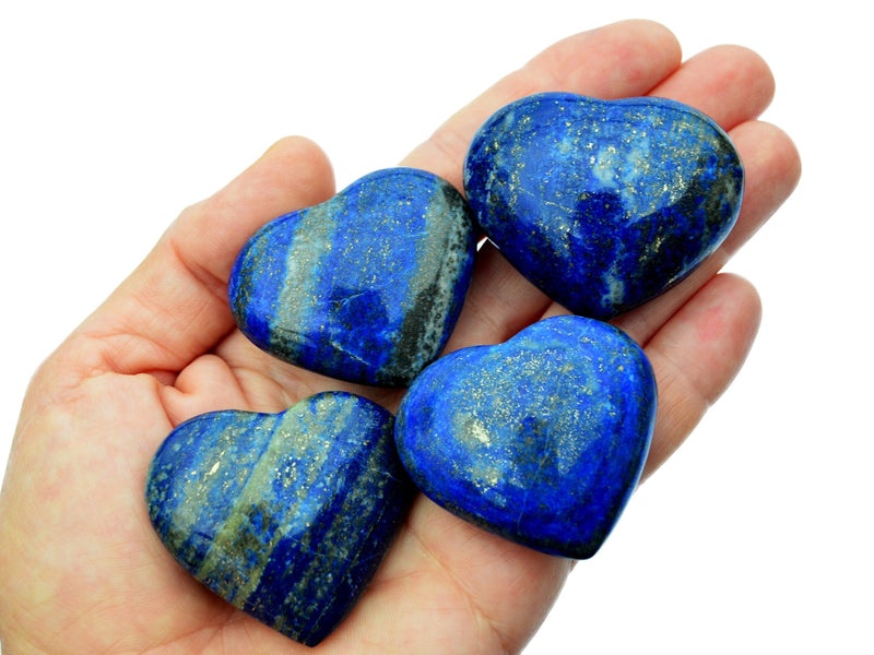 Three lapis lazuli crystals hearts 40mm-45mm on hand with white background