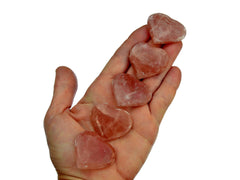 Five rose calcite hearts 30mm-35mm on hand with white background 