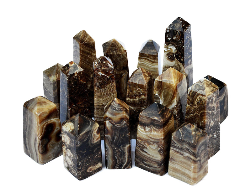 Several chocolate calcite crystal obelisks  different sizes on white background