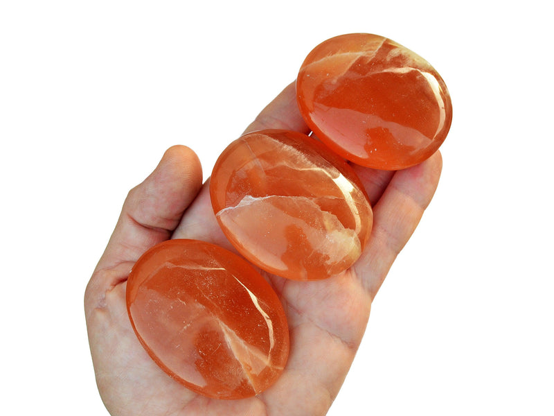 Three honey calcite palm stones 55mm-60mm on hand with white background
