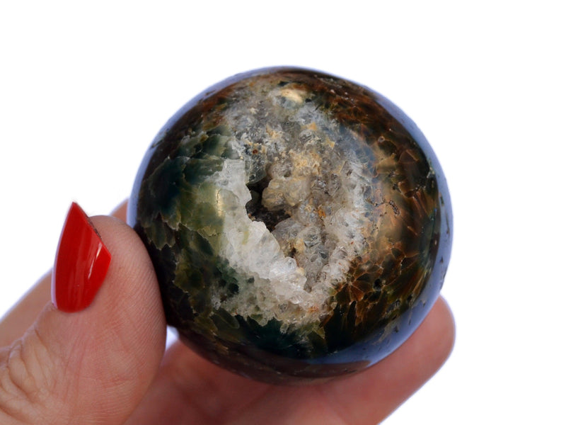 One ocean jasper crystal sphere 45mm  on hand with white background
