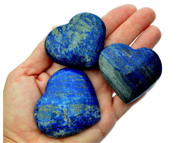 Three lapis lazuli heart shaped crystals 50mm-55mm on hand with white background