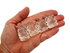 Four mini clear quartz crystal ganesha sculptures 30mm on hand with white background