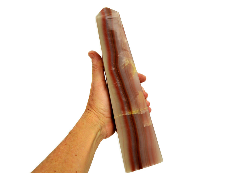 Extra large pink banded onyx obelisk 250mm on hand with white background