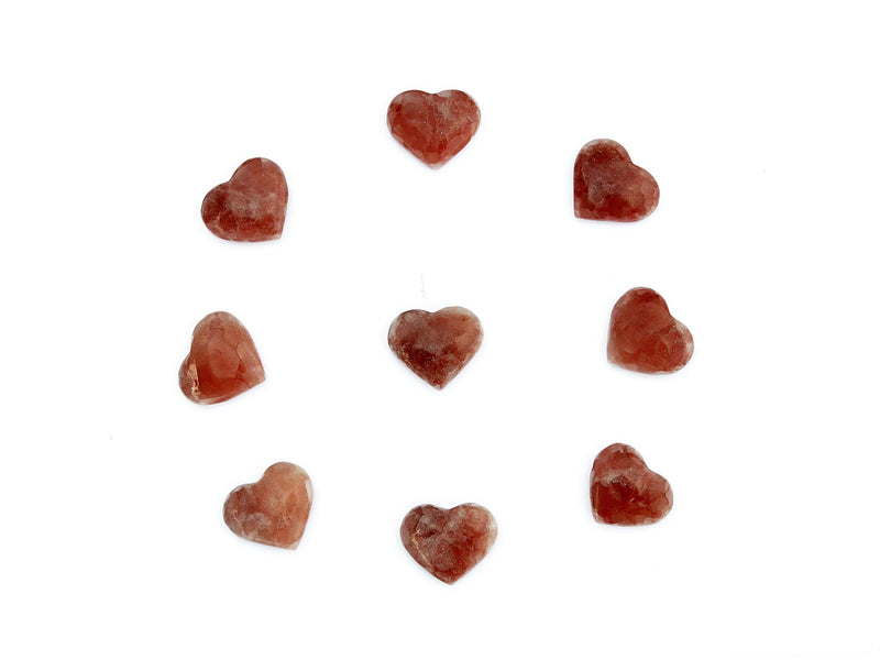 Several small rose calcite hearts 30mm-35mm forming a circle on white background