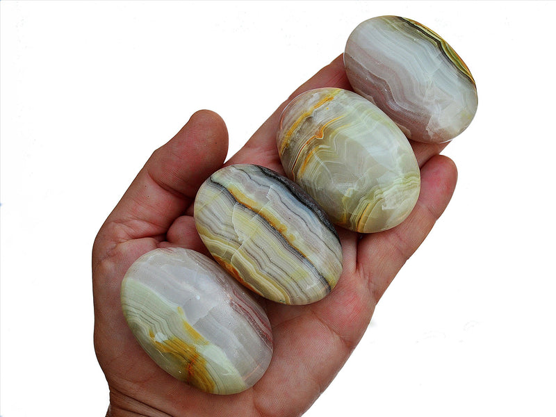 Four pink banded onyx palm stones 50mm-60mm on hand with white background