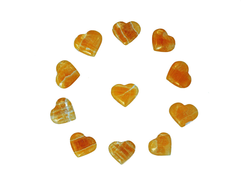 Some orange calcite crystal hearts small 30mm-35mm forming a circle on white background