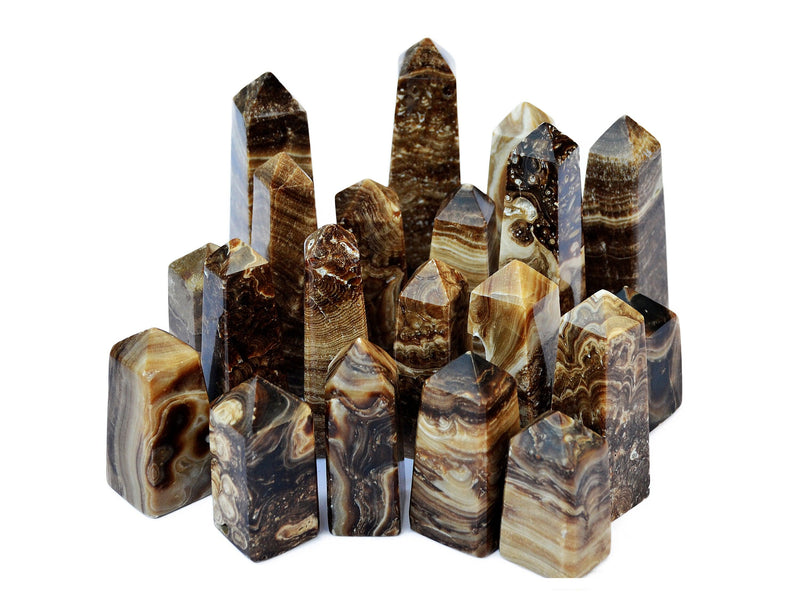 Several chocolate calcite crystal obelisks different sizes on white background