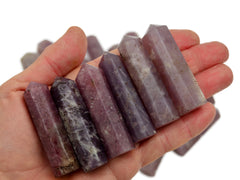 Six lepidolite faceted crystal points 55mm-60mm on hand with white background