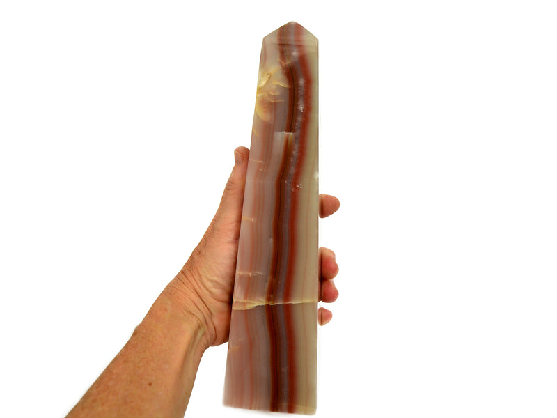 Extra large pink banded onyx obelisk crystal 250mm on hand with white background