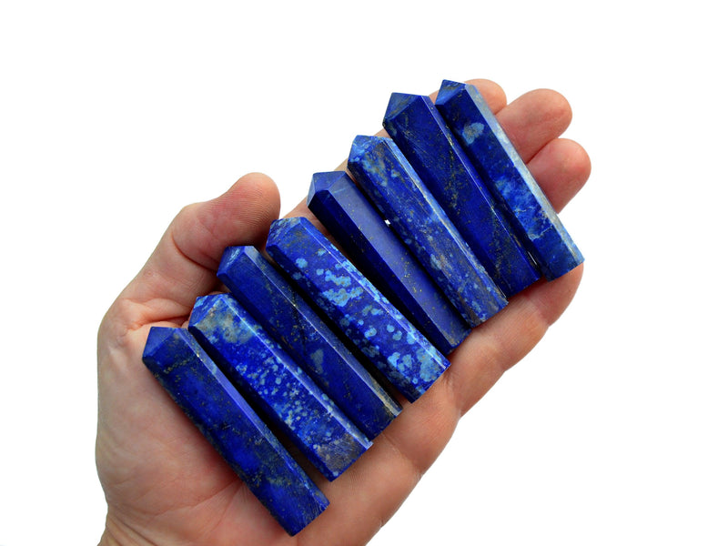 Eight lapis lazuli faceted tower points 55mm-65mm on hand with white background