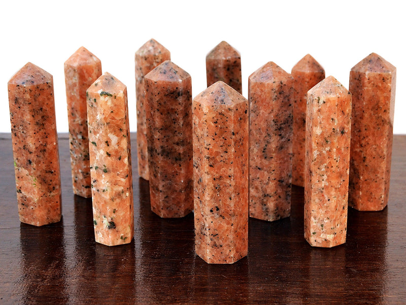 Several orange calcite crystal points 90mm on wood table
