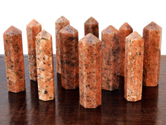 Several orange calcite crystal points 90mm on wood table