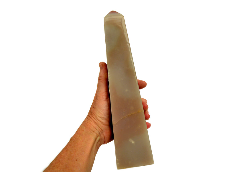 Reverse of big pink banded onyx obelisk 250mm on hand with white background