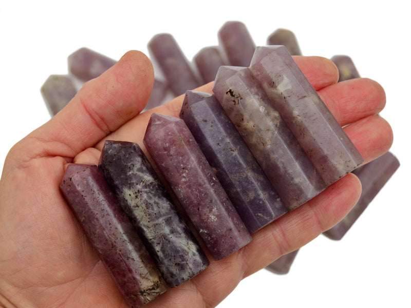 Sixe lepidolite crystal generators 55mm-60mm on hand with background with some points on white