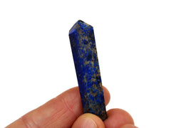 One small lapis lazuli crystal point 40mm on hand with white background