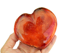 One extra large carnelian heart crystal on hand with white background