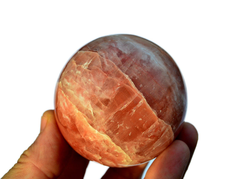 One rose calcite ball crystal 60mm on hand with white background