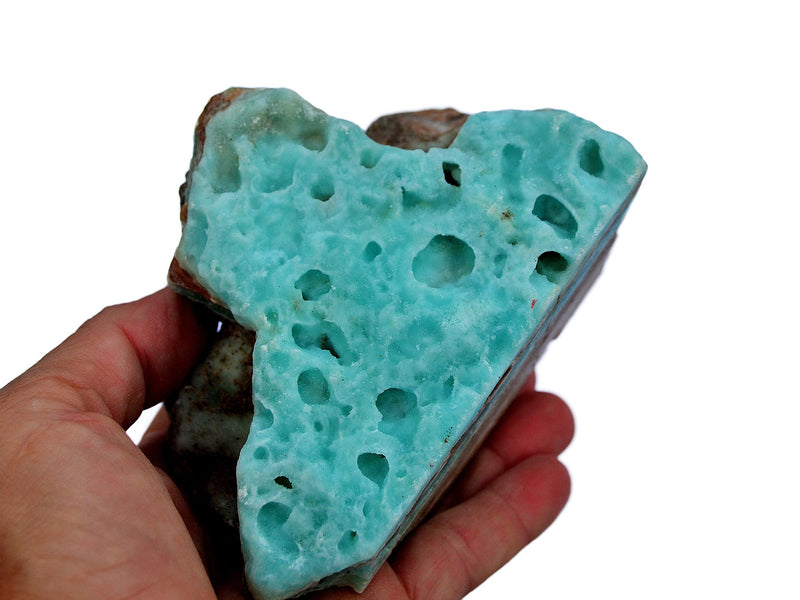 One rough blue aragonite rock on hand with white background