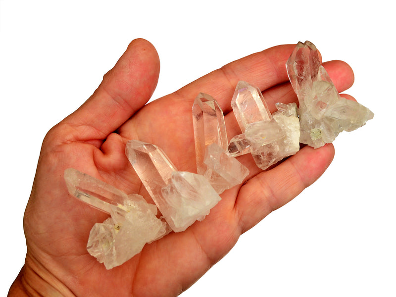 Five mini clear quartz clusters 30mm on hand with white background