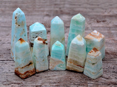 Several small blue caribbean calcite obelisk crystals on wood table