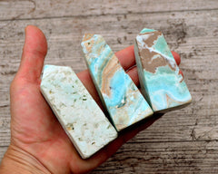 Three carribean blue aragonite points  on hand with wood background