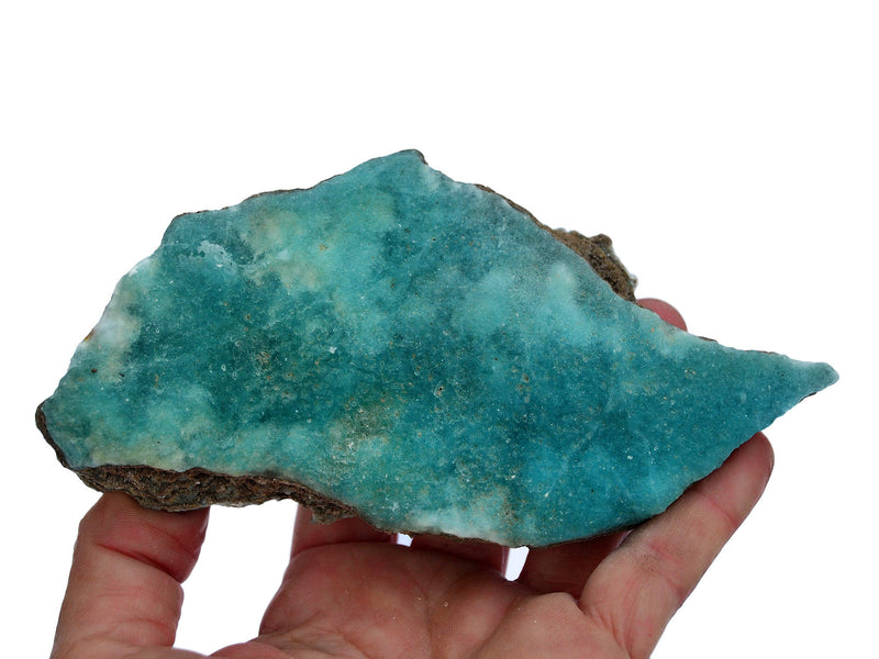 On rough blue aragonite on hand with white background