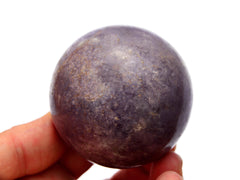 One purple lepidolite crystal sphere 60mm on hand with white background