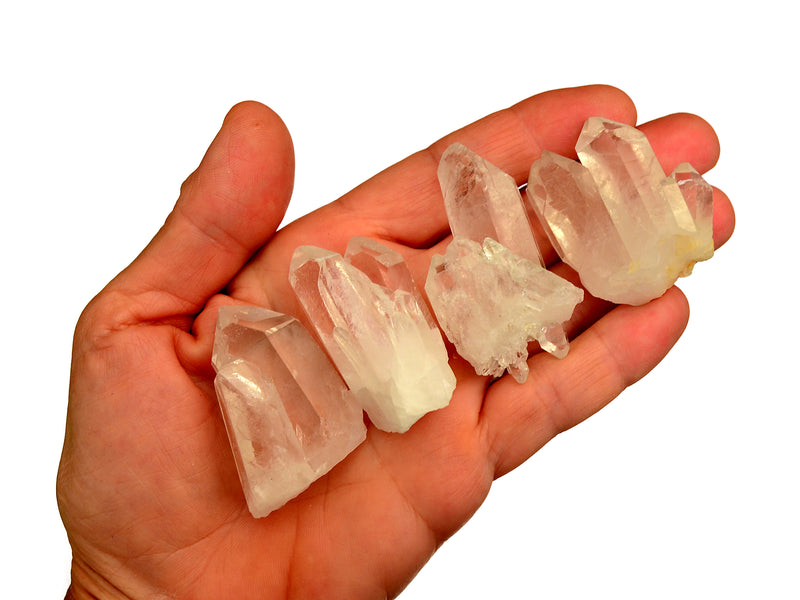 Hand holding a collection of clear crystal druzy points with white background