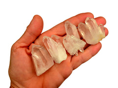 Hand holding a collection of clear crystal druzy points with white background