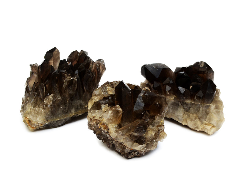 Three smoky quartz druzy crystals on white background