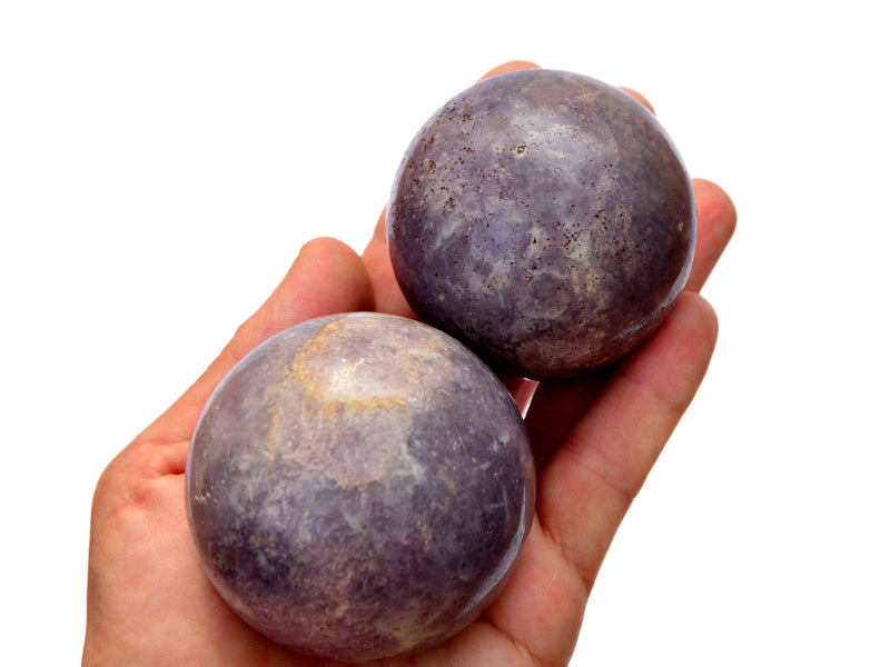 Two purple lepidolite spheres 45mm-60mm on hand with white background