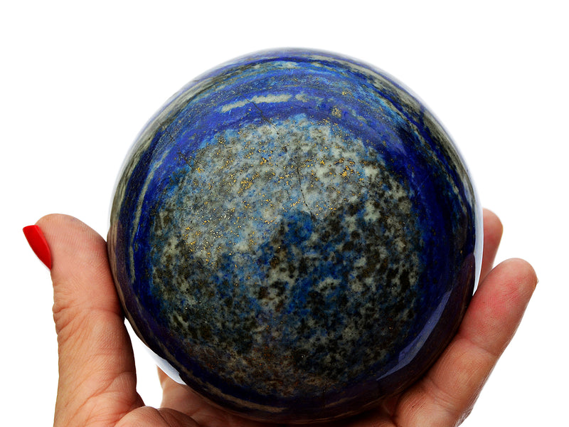 One large lapis lazuli crystal sphere on hand with white background