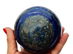 One large lapis lazuli crystal sphere on hand with white background